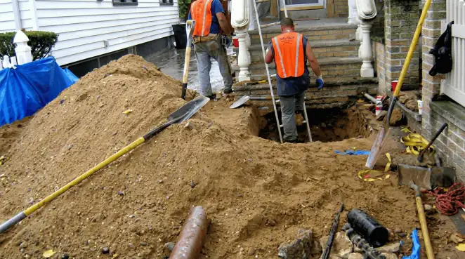 Contractors performing foundation protection and exterior drainage excavation near residential home steps in Yonkers, NY